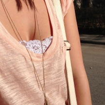 coral tee, gold feather necklace, lace bralet
